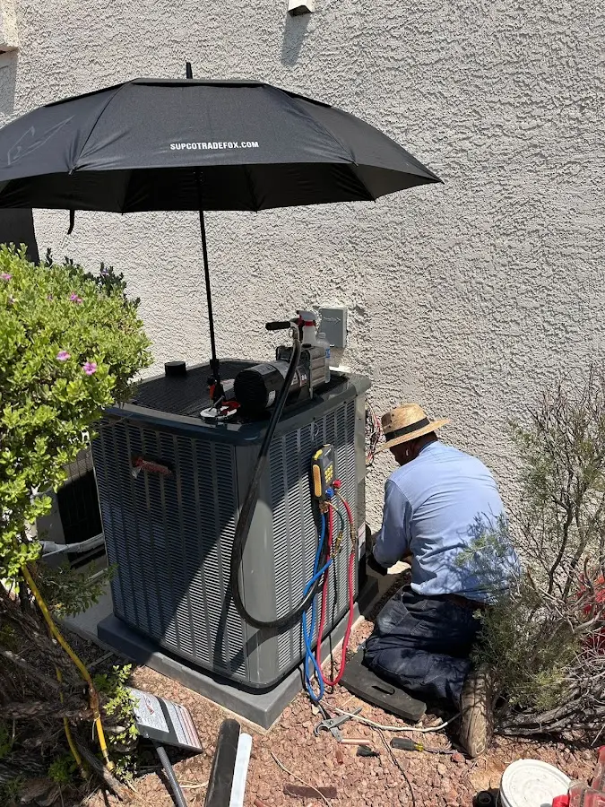 HVAC technician performing outdoor AC maintenance in Valley Falls